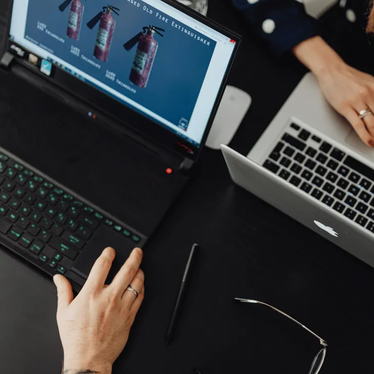 Hands working on a laptop at a business desk