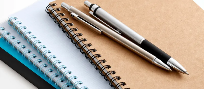 Spiral notebooks with premium metal pens on kraft paper
