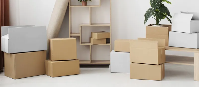 Stacked corrugated cardboard boxes in a bright storeroom